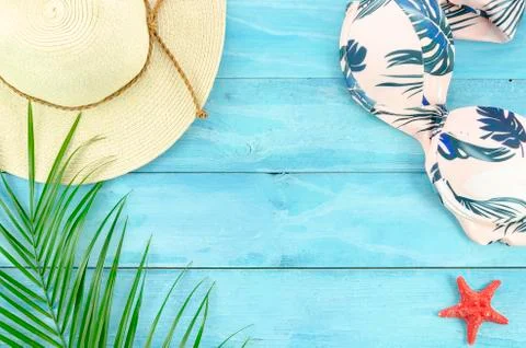 Flat lay summer background with plam leafs, bikini and hat on wooden planks Stock Photos