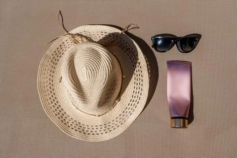 Flat Lay of Summer Essentials Straw Hat Sunglasses and Cosmetic Tube Fotos de archivo