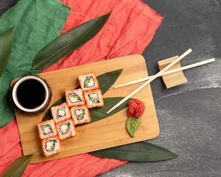 Flat lay. Sushi roll serving. Sushi set with salmon on cutting board with soy Stock Photos