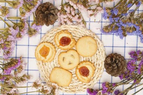 Flat lay of sweets, Butter cookie on rattan plate in center of statice flower Stock Photos