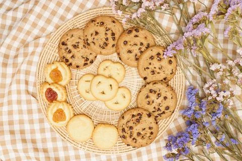 Flat lay of sweets, Butter cookie and chocolate chip cookie in rattan plate o Stock Photos