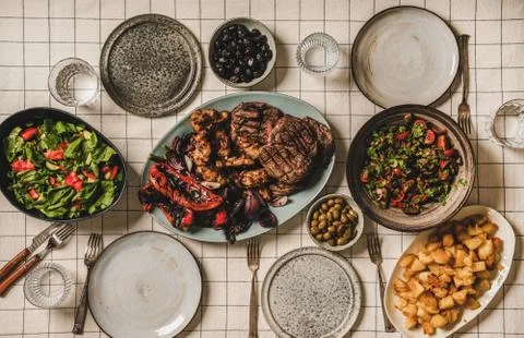 Flat-lay of table with grilled meat, chicken, vegetables, salads, potato Stock Photos
