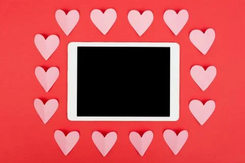 Flat lay of tablet computer with blank screen on red background with paper Stock Photos