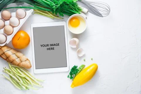 Flat lay with Tablet computer with fresh vegetables on white background, copy Stock Photos