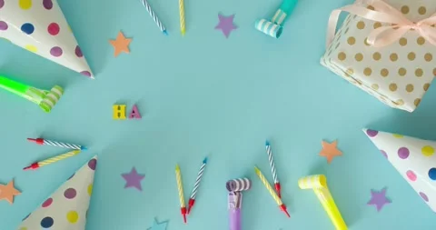 Flat lay with a text Happy Birthday, party hat, candles on a blue background Stock Footage 344844360