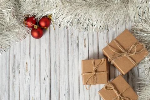 Flat lay three gift boxes on a wooden table decorated with a garland and red Stock Photos