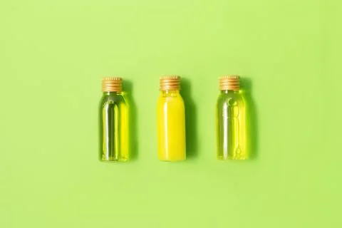 Flat lay of three small mockup bottles with spa cosmetic products on green Stock Photos