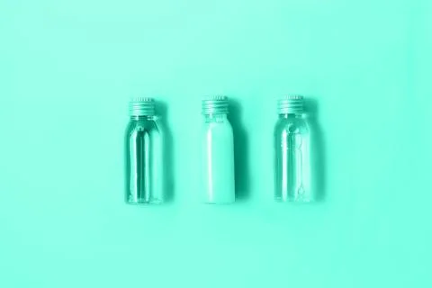 Flat lay of three small mockup bottles with spa cosmetic products in trendy mint Foto stock