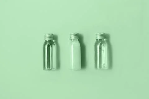 Flat lay of three small mockup bottles with spa cosmetic products in trendy mint Stock Photos