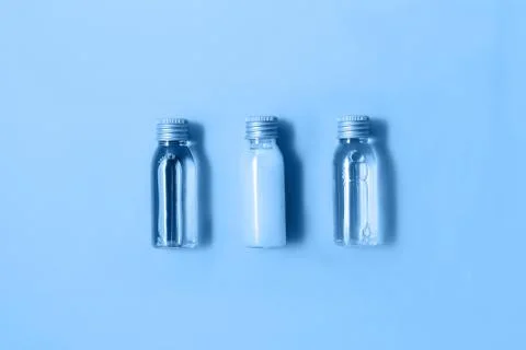 Flat lay of three small mockup bottles with spa cosmetic products in trendy blue Stock Photos
