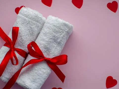 Flat lay with tiny heart-shaped papers, two white towels and space for text Stock Photos