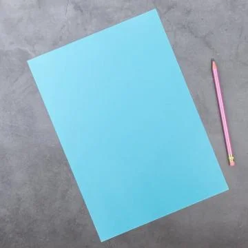 Flat lay, top view, blue sheet and pencil on a gray textured background. Rays Stock Photos