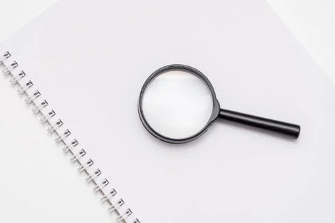Flat lay top view copy space notebook, mouse and magnifying glass white offic Фото
