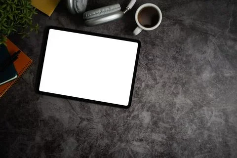 Flat lay, top view of digital tablet with empty display, coffee cup, headphone Stock Photos