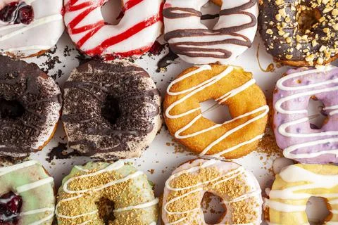Flat lay top view image of a dozen donuts on card board box. A delicious asso Stock Photos