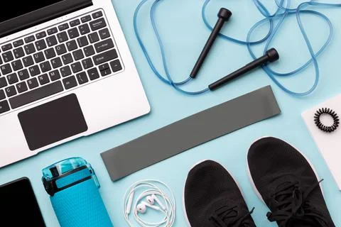 Flat lay top view of laptop with sport equipments on blue background 스톡 사진