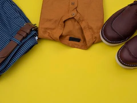 Flat lay, top view, men fashion casual clothing set isolated on yellow backgr Stock Photos