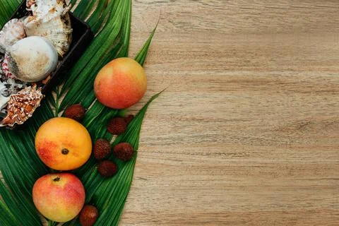 Flat lay, top view, Mix of Exotic fruits and palm leaf on a brown background Stock Photos