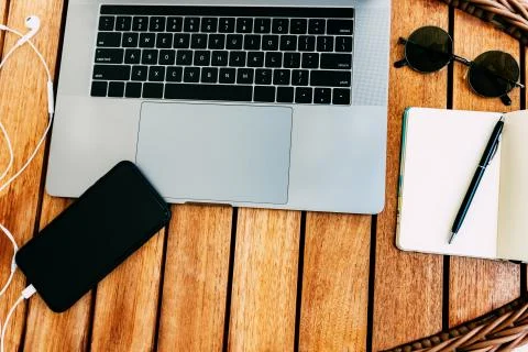 Flat lay, top view of the workspace with a laptop, on a brown wooden table Stock Photos