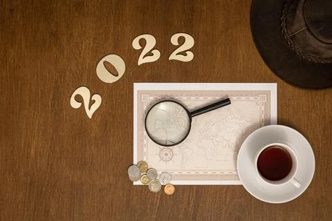 Flat lay travel composition with numbers 2022 and world map. Stock Photos