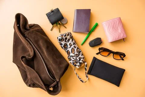 Flat lay of travel essentials with suede bag on pastel background Stock Photos