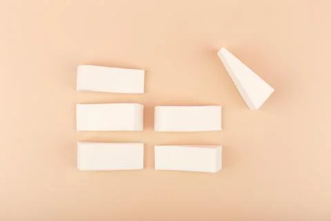 Flat lay with triangle shaped make up sponge son pastel beige background Stock Photos