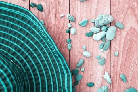 Flat lay with turquoise big hat and pebbles on the wooden surface Stock Photos