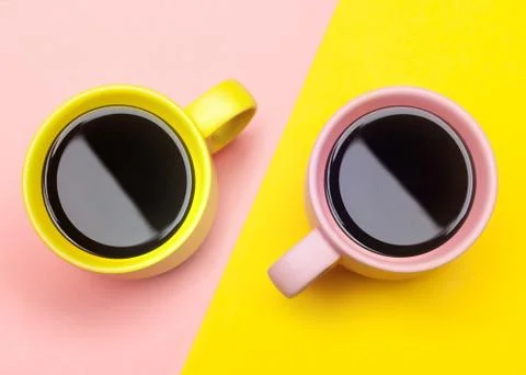Flat lay of a two coffee cups with pink and yellow Stock Photos