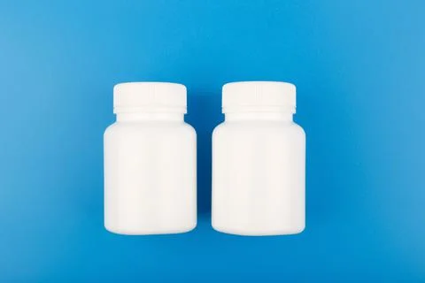 Flat lay with two medication bottles on blue background Stock Photos