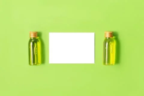 Flat lay of two small mockup bottles with spa cosmetic products on green Stock Photos