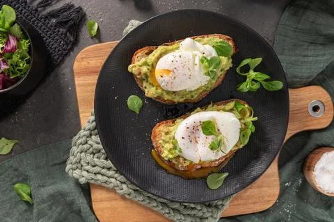 Flat lay of two sourdough toasts topped with mashed avocado and soft poache.. Foto stock
