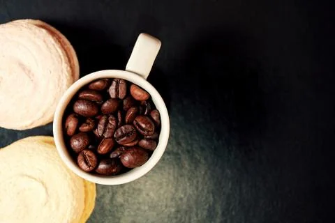 Flat lay with two tasty macaroons and a coffee cup with coffee beans Stock Photos