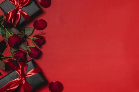 Flat lay valentine background decorated with gift box and red roses Stock Photos