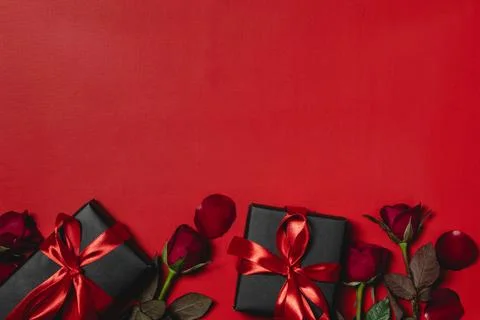 Flat lay valentine background decorated with gift box and red roses Stock Photos