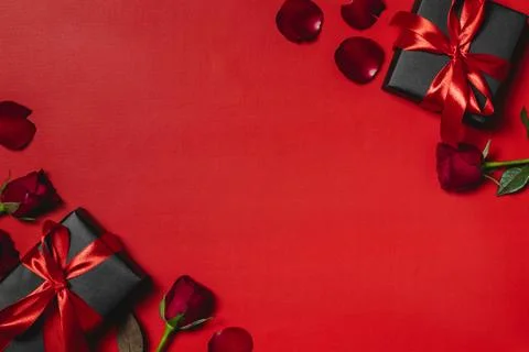 Flat lay valentine background decorated with gift box and red roses Stock Photos