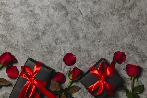 Flat lay valentine background decorated with gift box and red roses Stock Photos