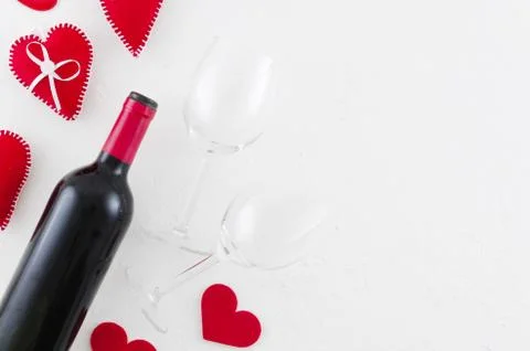 Flat lay Valentines day greeting card with wine bottle, felt hearts and Stock Photos