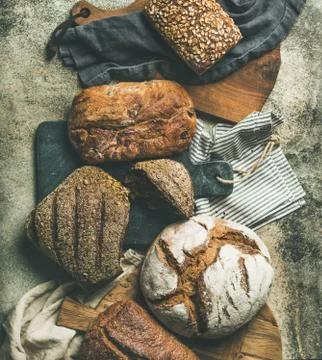 Flat-lay of various bread loaves on grey background, top view Foto stock