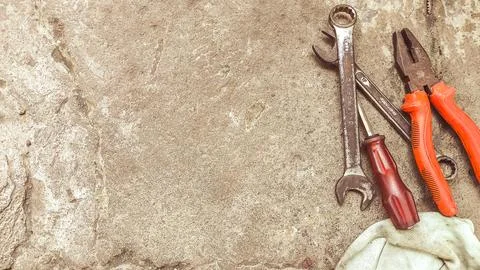Flat lay of various mechanical hand tools on a textured cement floor. Perfe.. Stock Photos