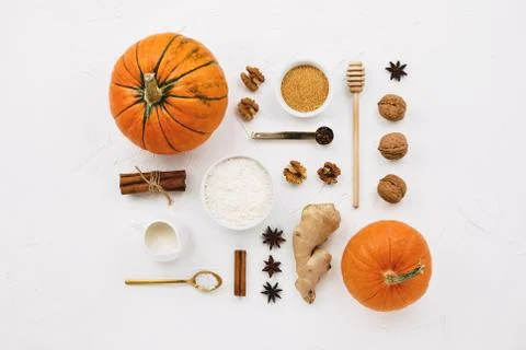Flat lay with various pumpkins, cinnamon stick, flour, spices, cane sugar and Foto stock