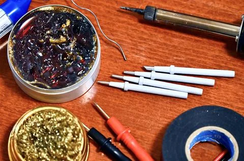 Flat lay of various soldering tools, rosin flux, and multimeter probes on a Stock Photos