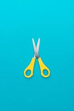 Flat lay vertical shot of opened yellow scissors with central composition Stock Photos