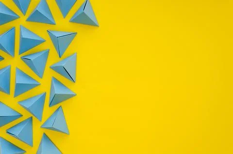 Flat lay vibrant colored paper pyramids with copy space Stock Photos