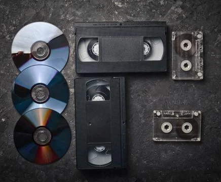 Flat lay video cassettes, CD's, audio cassette on a black concrete surface. R Stockfoto's