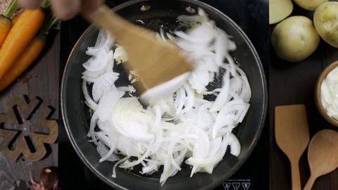 Flat lay video: chef stirs chopped onion by wooden kitchen spatula on the hot Video stock 114807576