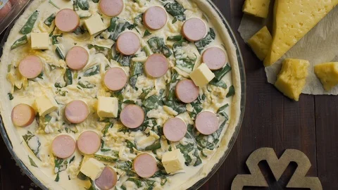 Flat lay video: the cook adds butter to the pie with cheese and sausages Stock Footage 114769570