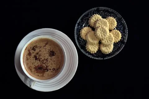 Flat lay view of a cup of coffee and a bunch of kue satu or kue koya Foto stock