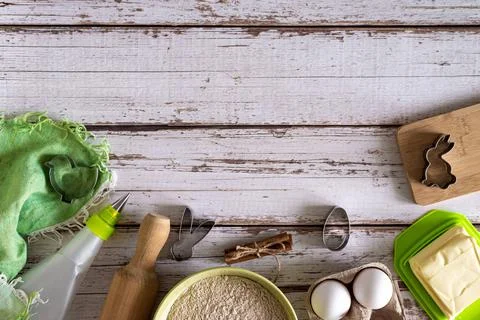 Flat lay view of Easter cookie baking ingredients and kitchen utensils, woode Stock Photos