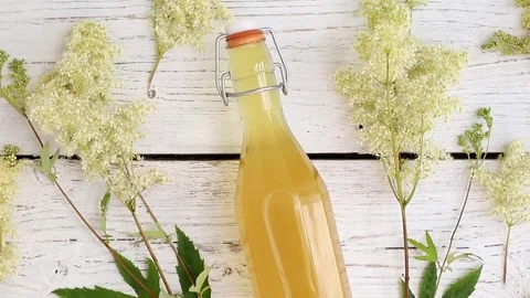 Flat lay view of homemade Meadowsweet Filipendula ulmaria flowers syrup bottle. Stock Footage 313937448