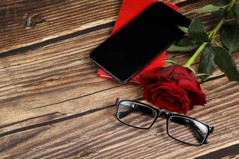 Flat lay view of a red notebook, smartphone, pen on a wooden background. Top Stock Photos